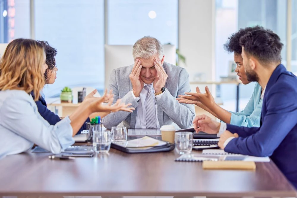 Businessman in meeting with headache, anxiety or stress with mental health emergency in work office. Sick senior company manager with burnout and frustrated with migraine pain, problems or fatigue